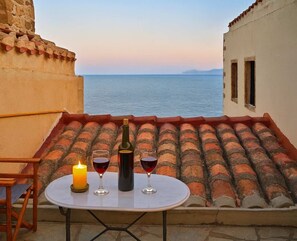 A table with two glasses of red wine and a candle on a terrace overlooking the sea. - Pablito House - Seaview Monemvasia Fortress Nest (Monemvasia)