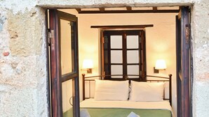 Une chambre à coucher avec un lit, deux lampes de chevet, une fenêtre et une porte.