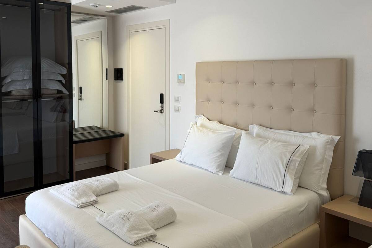 Ett modernt hotellrum med en stor säng, en rymlig klädkammare och ett separat badrum.
