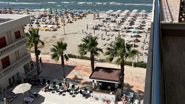 A hotel with a pool, beach view, and outdoor seating area. - Adria Palace Hotel (Rrashbull)