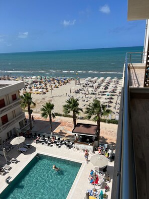 A hotel with a pool, beach view, and outdoor seating area. - Adria Palace Hotel (Rrashbull)