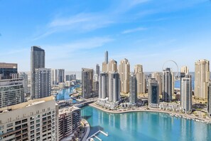 Ein hoch aufragendes Stadtgebiet mit modernen Gebäuden, einer Marina und wolkenlosem, blauem Himmel.