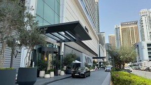 Un edificio moderno con fachada de vidrio y entrada cubierta.