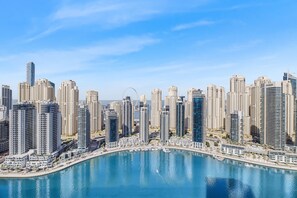 A high-rise urban area with modern buildings, a marina, and a Ferris wheel. - DXB - Vida Residences Dubai Marina - 3007 - DM (Dubai)