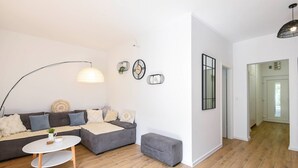 A modern living room with a grey sofa, a round coffee table, and a pendant light. - Comfortable 2-Bedroom Family Apartment in the small, quiet street. (Orebic)
