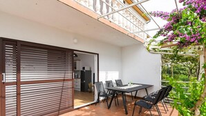 A patio with a table and chairs, a sliding door, and a view of a kitchen and balcony. - Comfortable 2-Bedroom Family Apartment in the small, quiet street. (Orebic)