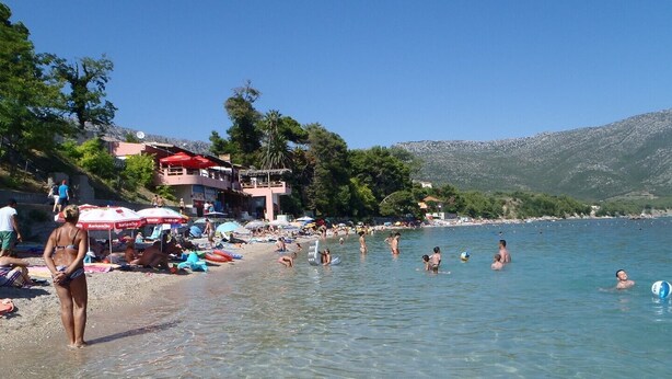 A beach with clear water, umbrellas, and people. - Comfortable 2-Bedroom Family Apartment in the small, quiet street. (Orebic)