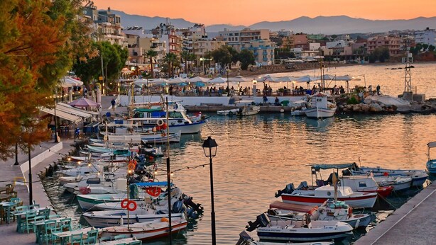 A marina with boats docked, a waterfront café area, and buildings in the background. - Casa Gardenia -modern apartment next to the beach and near old town (Chania)