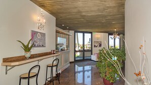 Une cuisine moderne avec un plan de travail en marbre, des tabourets de bar et une plante en pot.