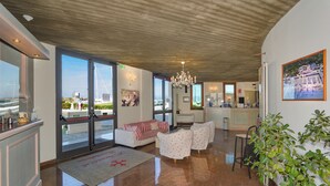 Un hall d’entrée spacieux au design moderne, comprenant un comptoir d’accueil, un espace salon et de grandes fenêtres offrant une vue sur la ville.