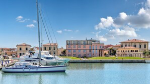 Un port de plaisance avec des bateaux amarrés, des bâtiments aux toits rouges et un ciel bleu clair.