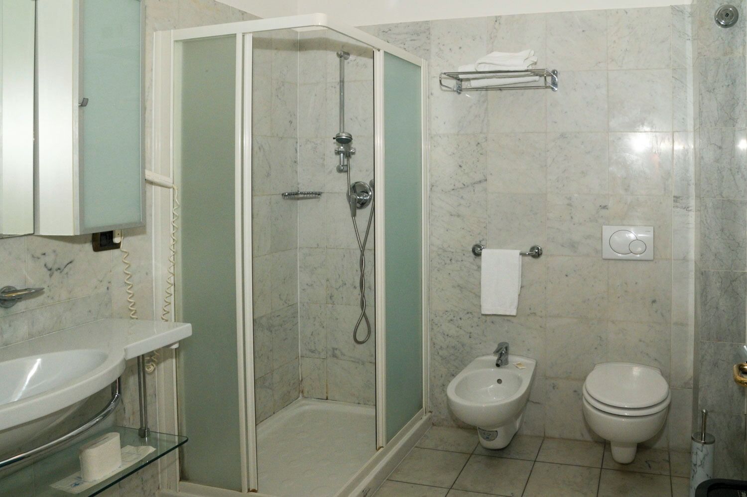 Ein Badezimmer mit Duschkabine, Waschbecken, Bidet und Toilette.