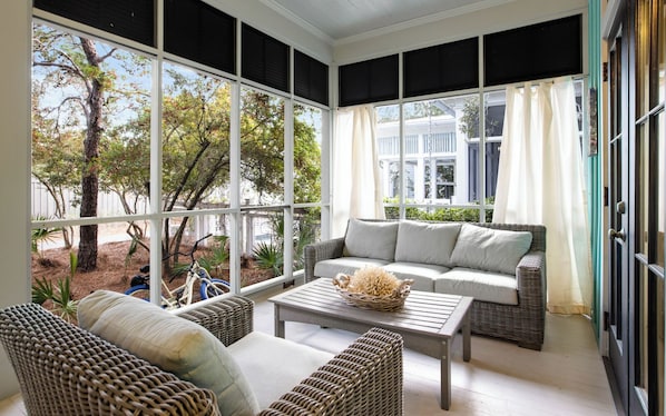 A sunroom with wicker furniture, a coffee table, and a view of the outside. - WaterColor Park District - Pools - Beach Access (Santa Rosa Beach)