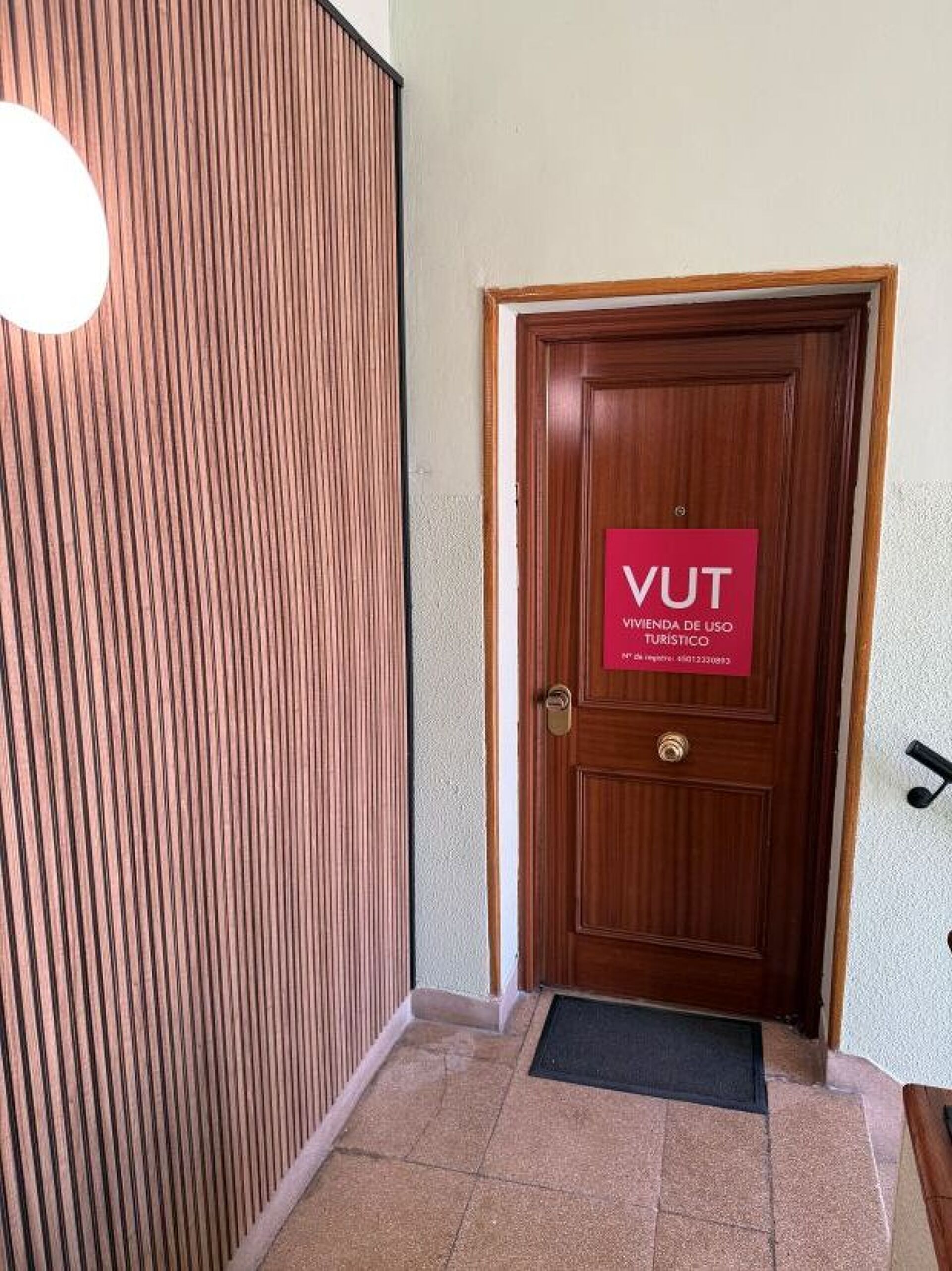 A wooden door with a sign that reads 'VUT' and 'VIVIENDA DE USO TURISTICO'.