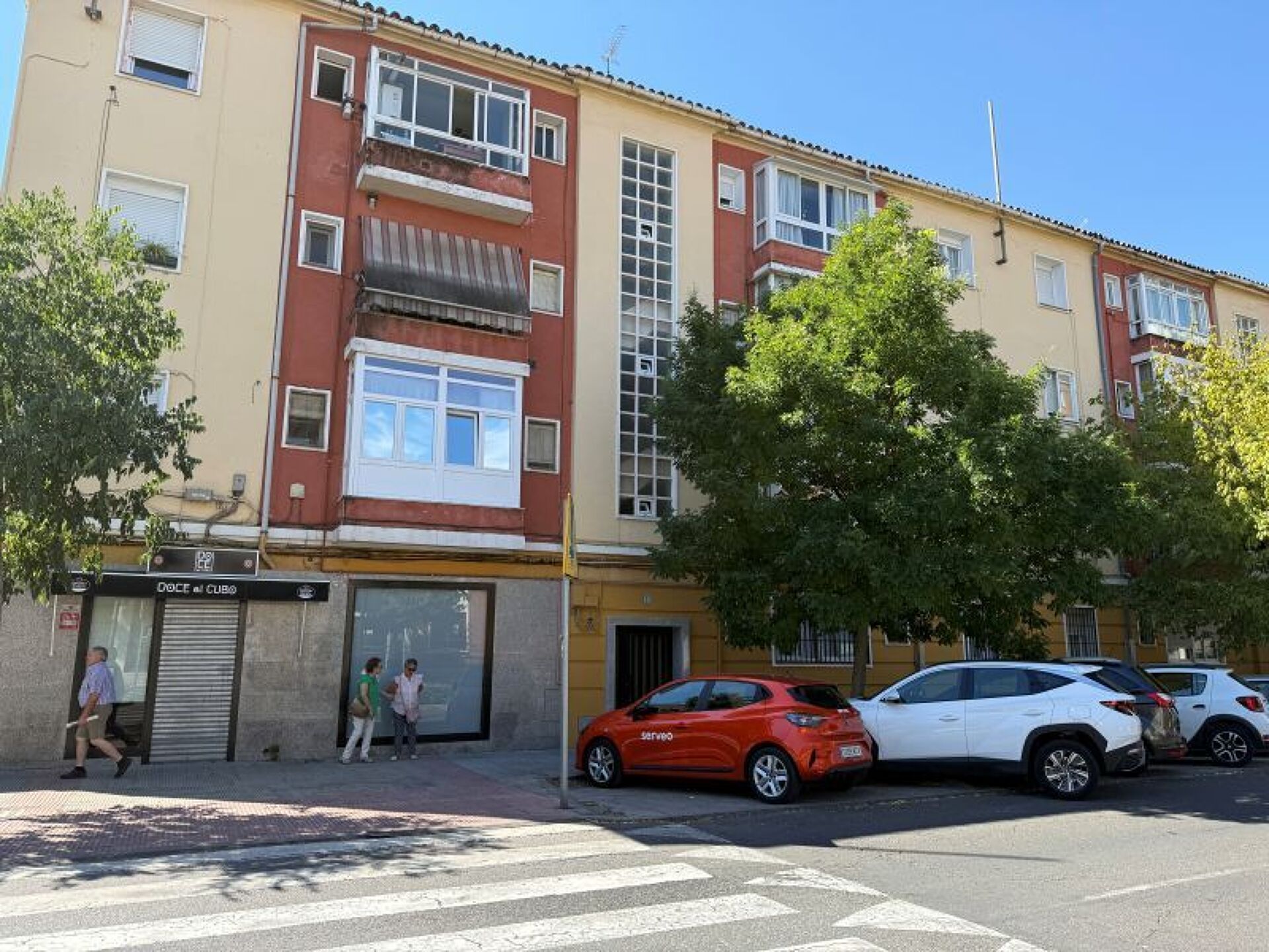 Een meerlaags woongebouw met een winkel op de begane grond.