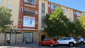 Un edificio residencial de varios pisos con un local comercial en la planta baja.