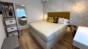 A bedroom with a bed, a wardrobe, a desk, and a mirror. - PIO XII XXI - B - Bright, central, and cozy apartment. - Deluxe 1 bedroom apartment (Talavera de la Reina)