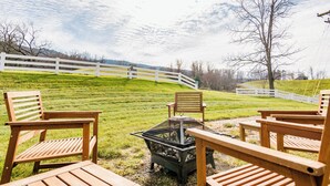 A grassy outdoor area with wooden chairs and a fire pit. - Across from the Springs, Access to Pool + Hot Tub (Warm Springs)