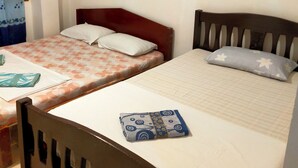 A hotel room with two single beds, a painting on the wall, and a window with curtains. - morenos cottage  (Boracay Island)