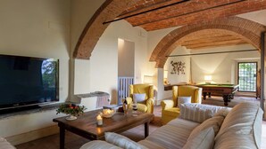 A spacious living room with a brick ceiling, a billiards table, and a flat-screen TV. - Castellare in Poggio 10 Emma Villas (Castellina in Chianti)