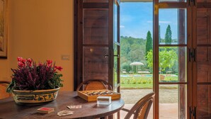 A wooden table with a chessboard, playing cards, and a potted plant. - Il Cerreto 11 Emma Villas (Pontedera)
