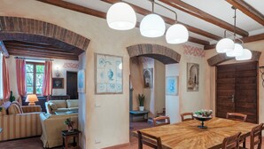 Un vaste espace de vie comprenant une table à manger en bois, des sièges confortables et une cheminée.