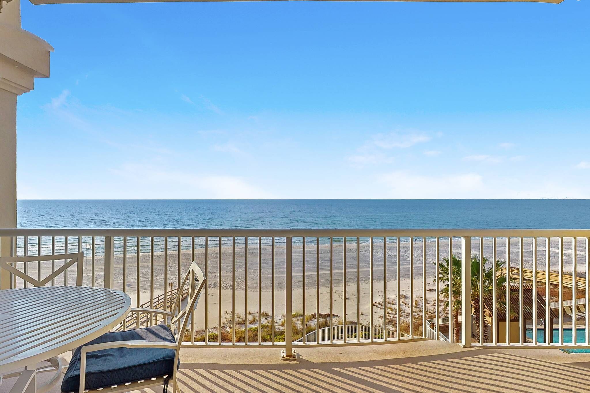 Un balcón con vista a la playa y al océano.