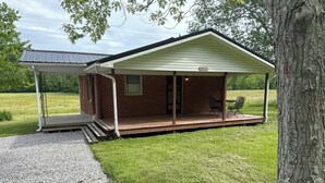 A small, single-story brick house with a covered porch and a number '1951' sign. - Charming 2-bedroom cottage in Brodhead with WiFi and AC (Brodhead)
