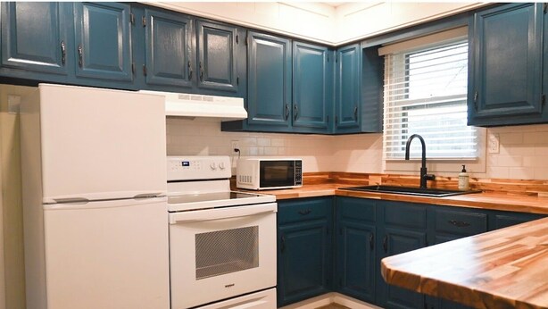 A kitchen with teal cabinets, a white refrigerator, a microwave, and a wooden countertop. - Charming 2-bedroom cottage in Brodhead with WiFi and AC (Brodhead)