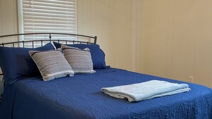A bedroom with a bed, pillows, and a window with blinds. - Charming 2-bedroom cottage in Brodhead with WiFi and AC (Brodhead)