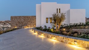 A modern building with a stone facade and a paved pathway leading to it.