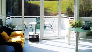 A sunlit patio with a glass table, chairs, and a sofa. - BLACK&WHITE vacation home (Niederösterreich)