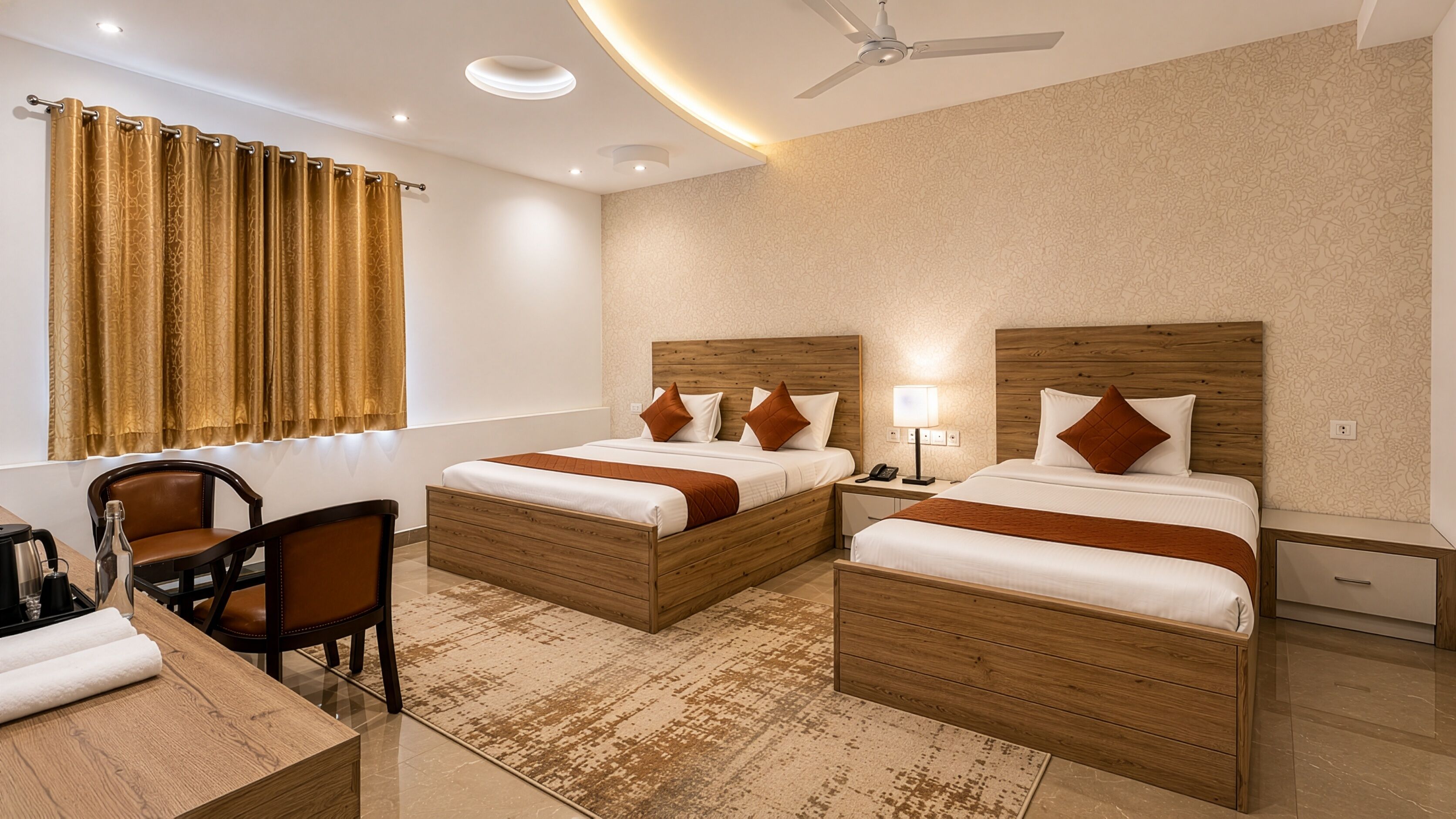 A hotel room with two beds, a desk, a chair, a ceiling fan, and a window with curtains.