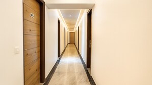 A hotel corridor with wooden doors, numbered 406, and a marble floor.