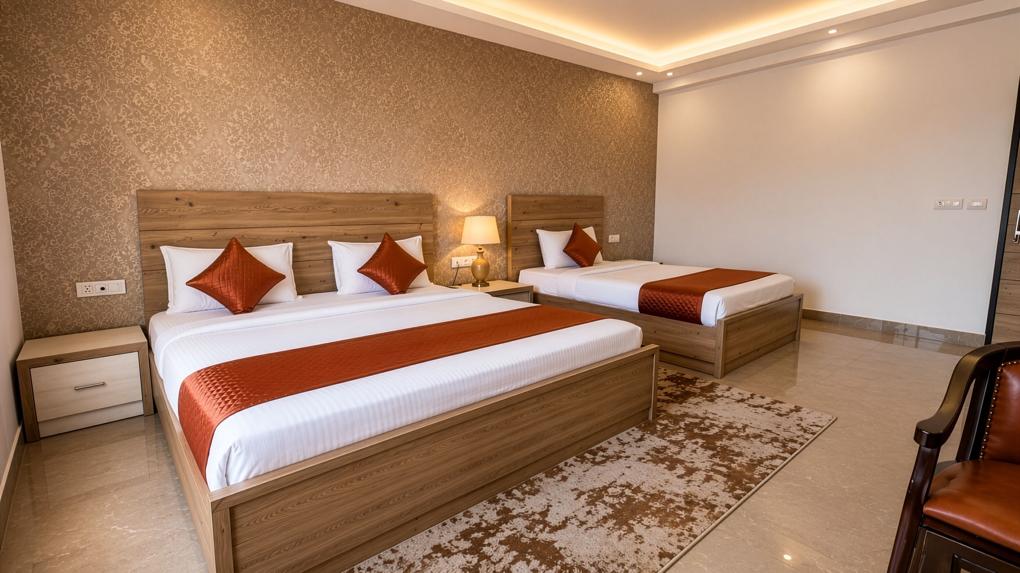 A hotel room with two wooden beds, a nightstand, a lamp, and a patterned rug.