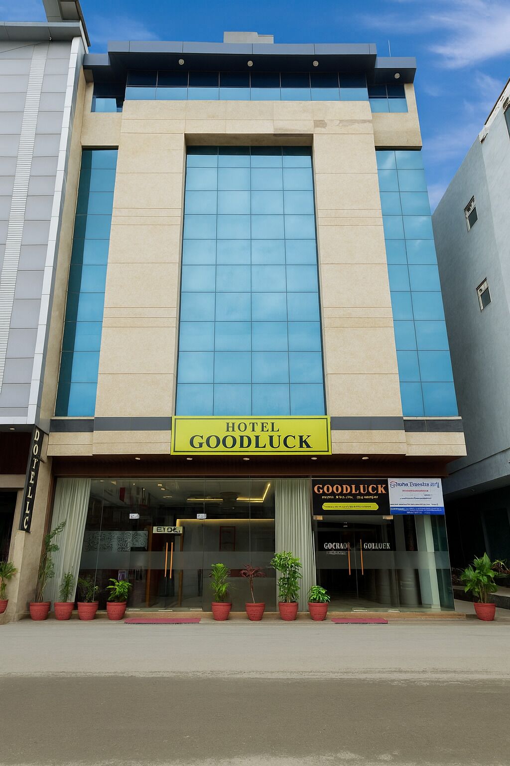 Un hôtel appelé « Hotel Goodluck », doté d’une façade moderne, de grandes fenêtres et d’une enseigne.
