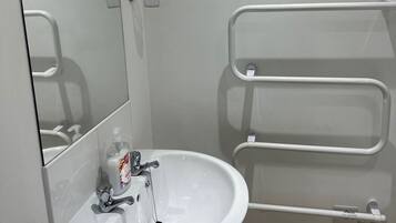 A bathroom with a white sink, a mirror, and two motivational signs on the wall.