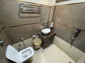 Un baño pequeño con inodoro, lavamanos y ducha.