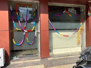 Entrada de un edificio decorada con guirnaldas coloridas y una bandera.