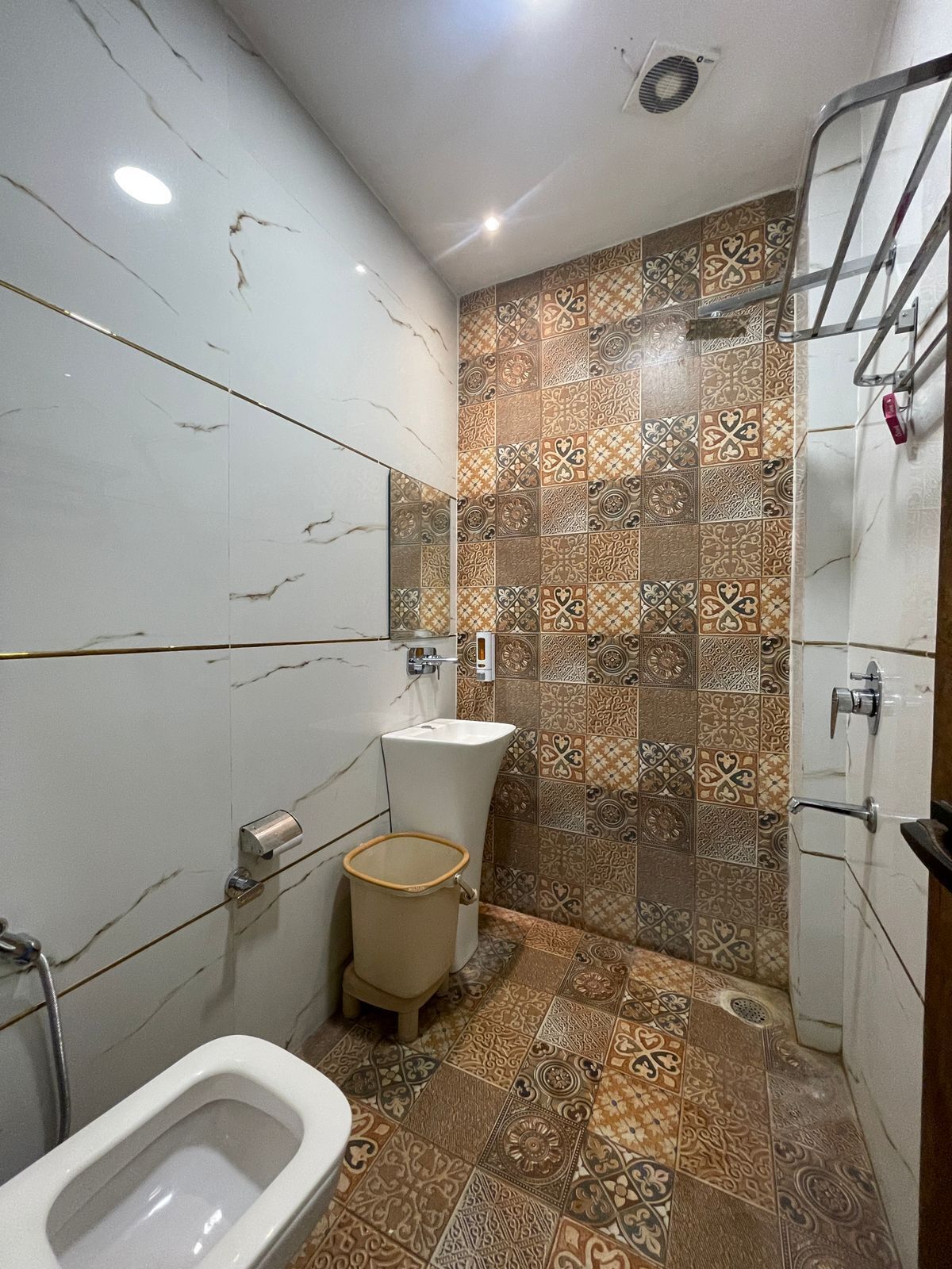 A bathroom with a toilet, bidet, and shower area.