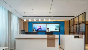 Ein moderner Empfangstresen mit zwei Monitoren, einem großen Bildschirm und einem klaren, minimalistischen Design.