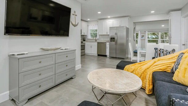 A modern living room with a grey sofa, a round coffee table, and a flat-screen TV mounted on the wall. - King Bed. Great Parking. Message with Questions.

 (Titusville)