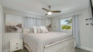 A bedroom with a bed, a nightstand, a ceiling fan, and a window with curtains. - King Bed. Great Parking. Message with Questions.

 (Titusville)