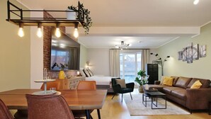 Ein modernes Wohnzimmer mit Essbereich, einer Couch und einem Bett.