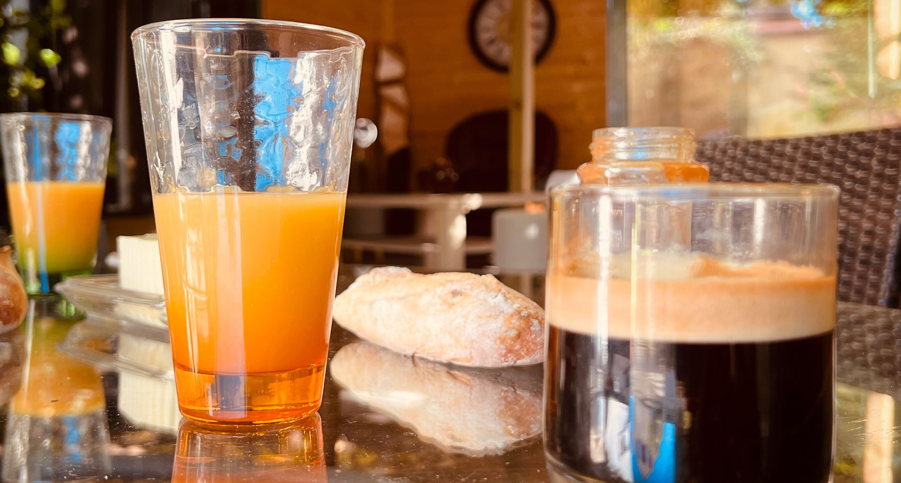 Una taula amb un got de suc d'aranja, un got de cervesa negra i una ampolla de cervesa.
