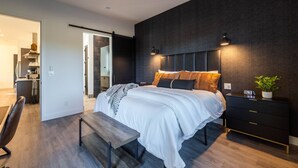 A modern bedroom with a bed, bedside tables, a bench, and a ceiling fan. - 3 Villas/30 Guests: Walk to Troon North Golf Club (Scottsdale)