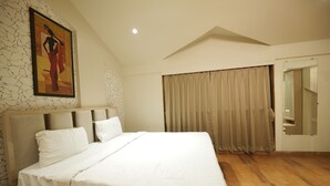 A bedroom with a large bed, a headboard, a painting, a window with curtains, and a mirror. - Warm Wood Villa By 97RoyalVista (Mawal)