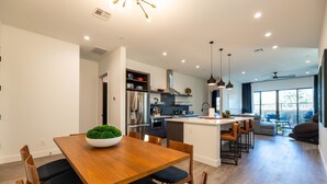A modern kitchen with a central island, built-in appliances, and pendant lighting.