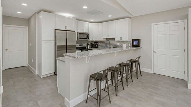 A modern kitchen with white cabinets, stainless steel appliances, and a granite countertop. - Park Bliss Unit 4. Private Suite
 (Titusville)