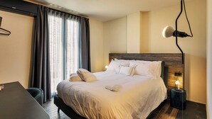 A neatly made bed with pillows and a bedside table, a desk, and a lamp. - Etrus Boutique Room Amalfi (Amalfi)